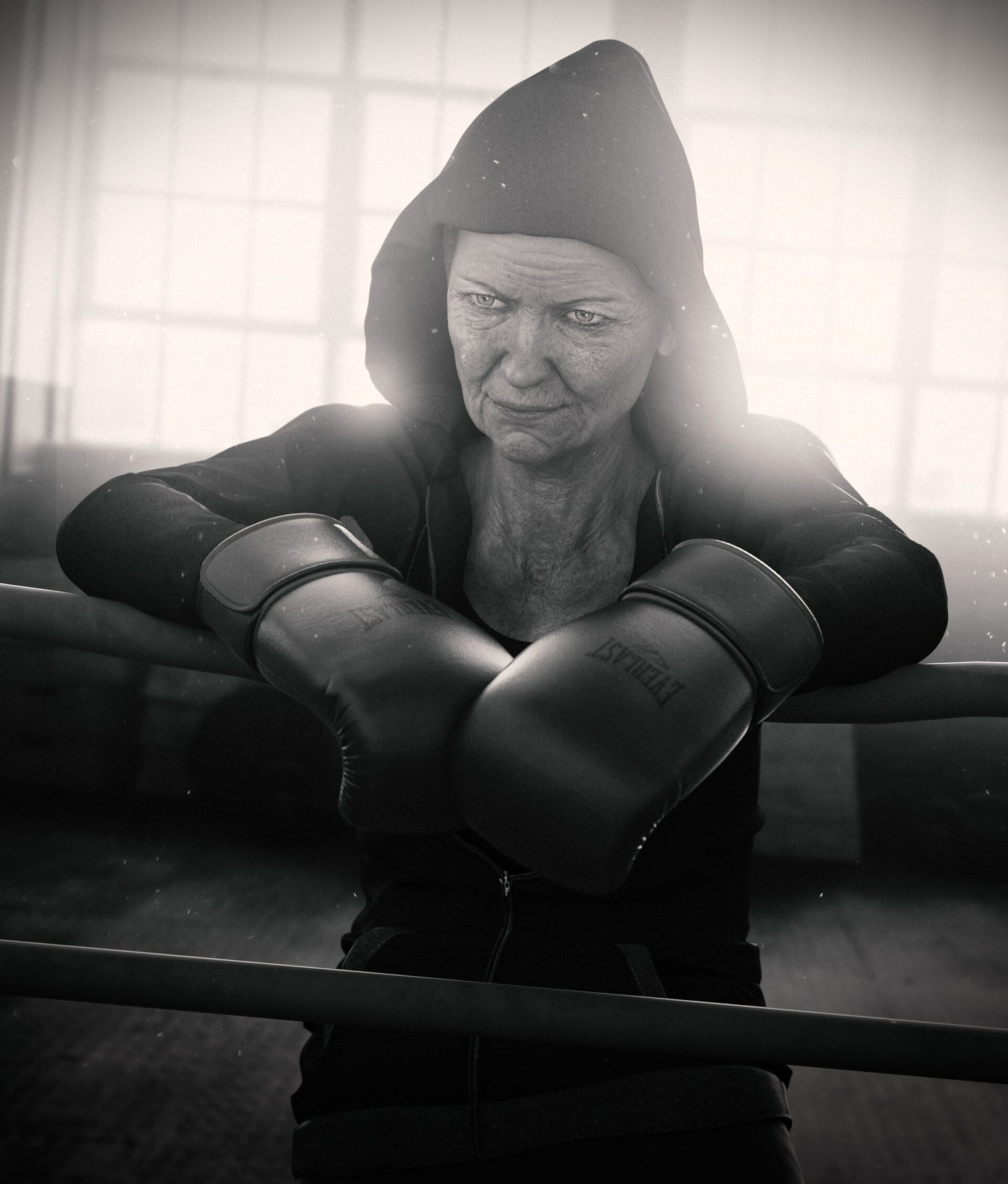 Portrait en noir et blanc d’une boxeuse âgée, capuche et gants, appuyée sur les cordes du ring